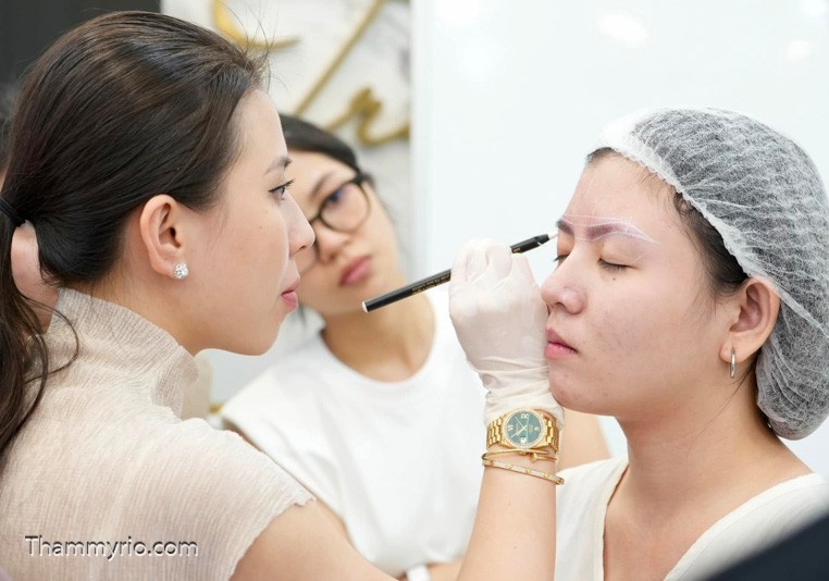 Professional expert at Rio Beauty Clinic performing a hyper-realistic Hairstroke eyebrow procedure for a client.