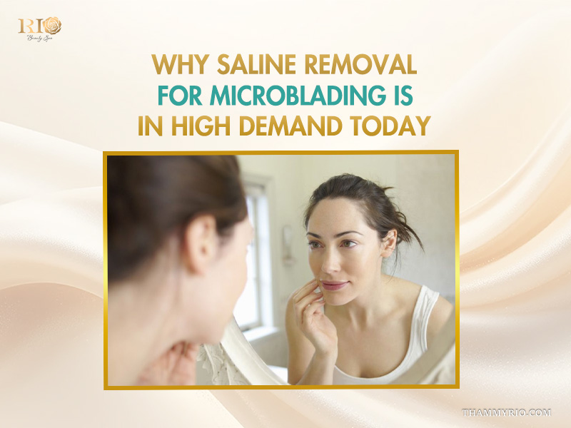 Woman looking in mirror considering saline removal for microblading procedure.