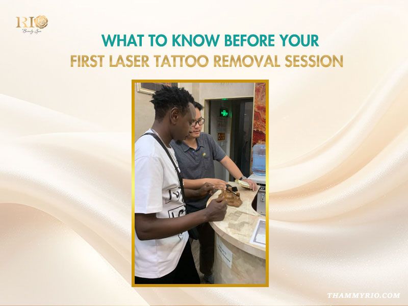 A consultant advising a foreign male client at the reception desk for a tattoo removal first session.