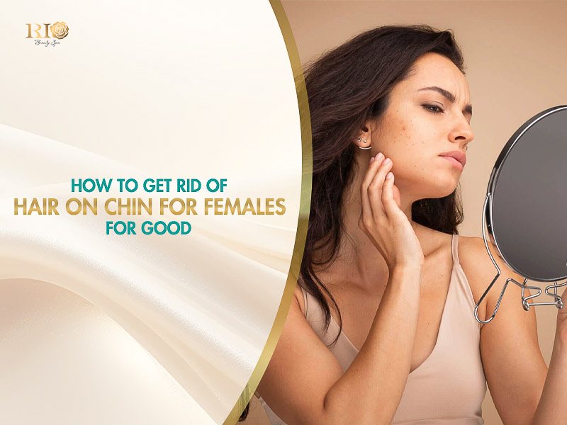 A concerned woman holding a small mirror and checking unwanted hair on chin for females under warm, natural light.