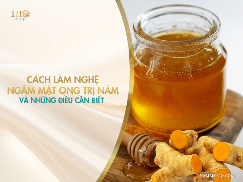 Hũ mật ong vàng sóng sánh bên củ nghệ tươi cắt lát và gáo múc gỗ trên banner hướng dẫn làm nghệ ngâm mật ong trị nám